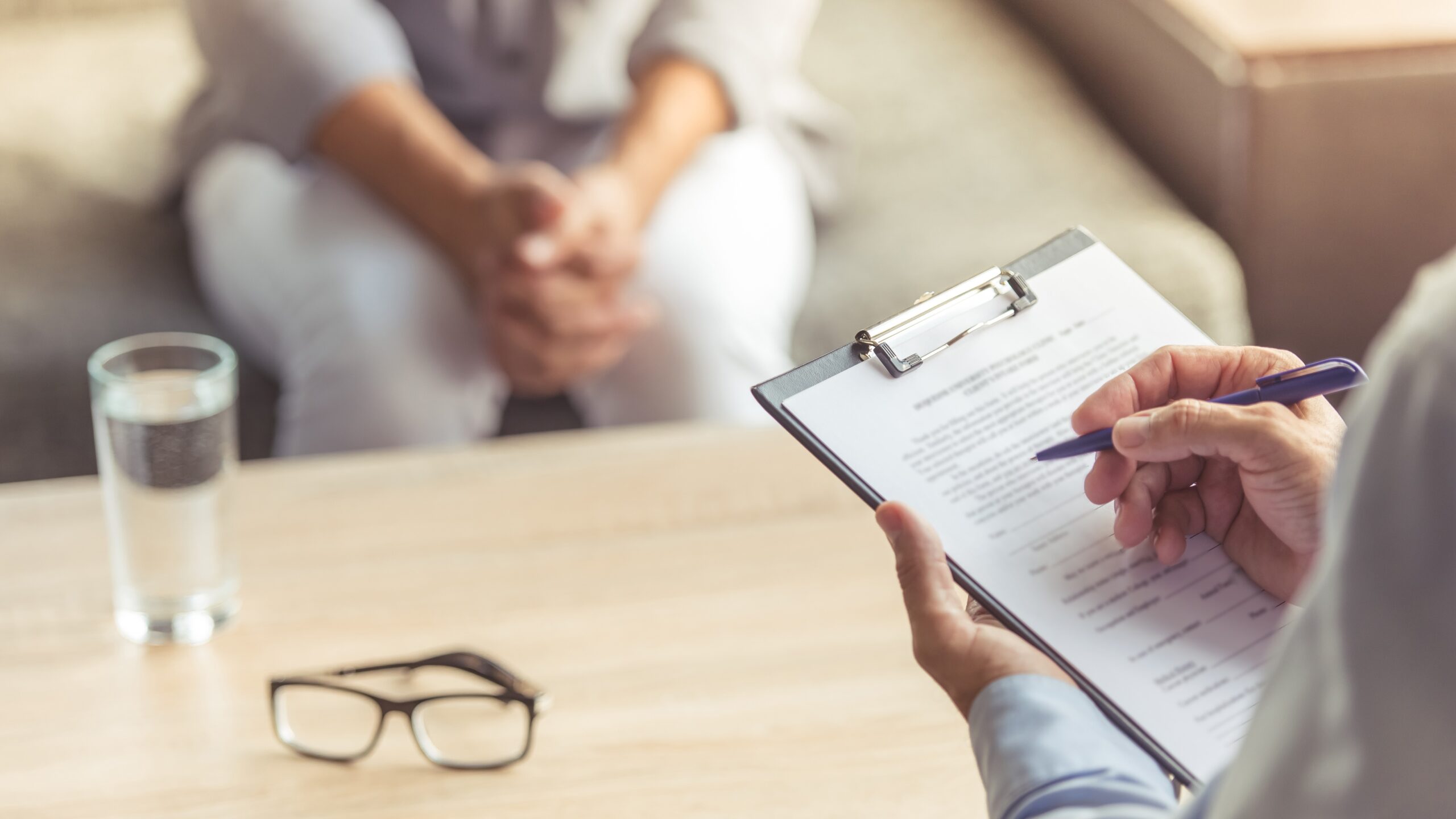 Man being interviewed by other man holding clipboard, sick leave concept