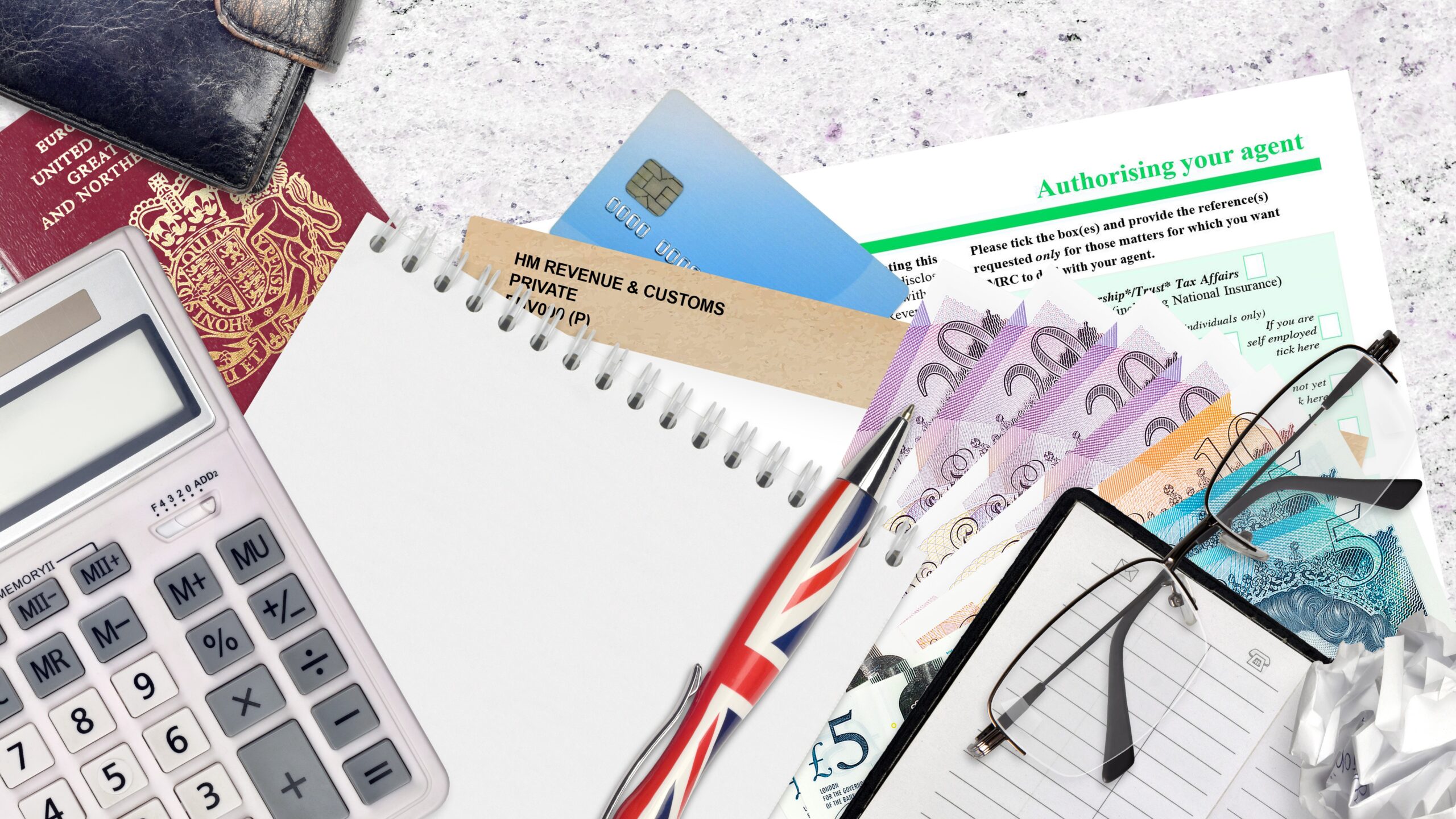 calculator, spectacles, HMRC forms on desk, corporation tax concept