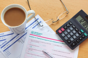 Coffee cup on tax demand, calculator, PAYE audit concept