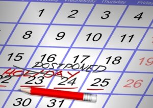 Calendar with words 'holiday postponed' written on it