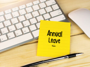 Post-It note saying 'Annual Leave' propped on keyboard, SSP concept