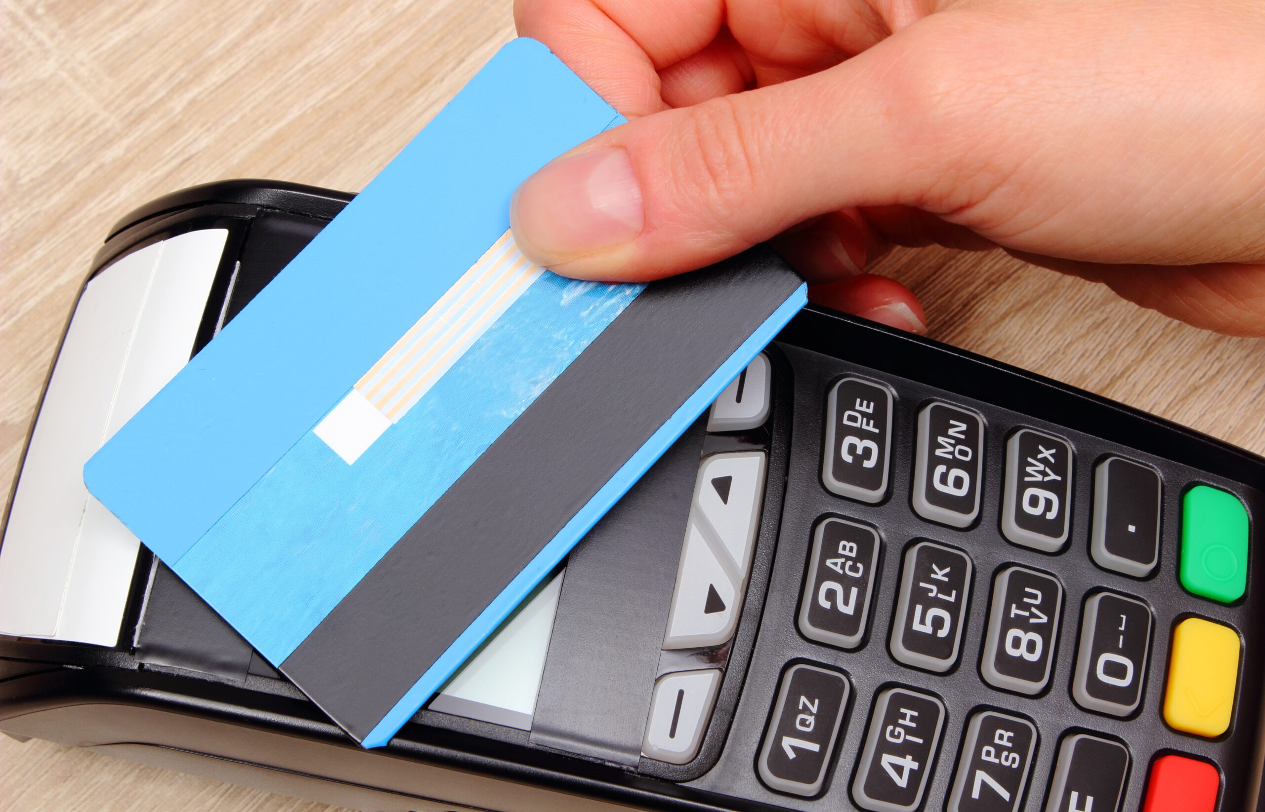 Hand of woman paying with contactless credit card with NFC technology, finance concept