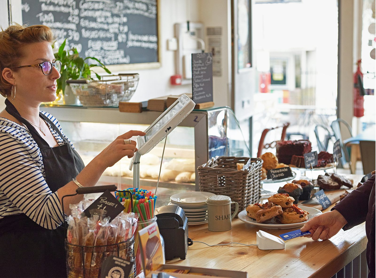 Female cafe owner taking Square card payment