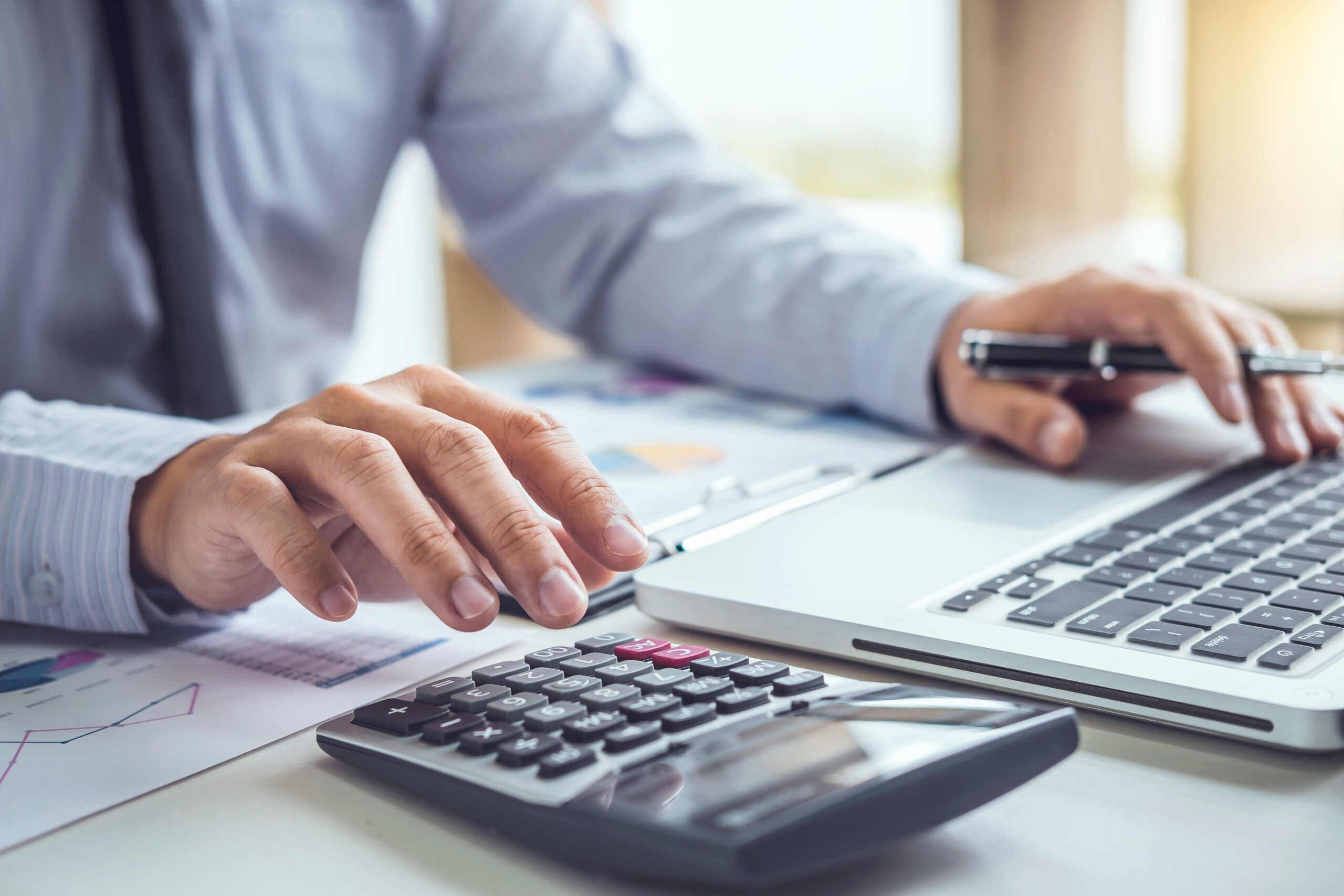 Man operating calculator to illustrate piece on benefits of SEIS/EIS