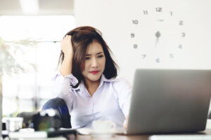 Confused businesswoman working at laptop, IR35 tax changes concept