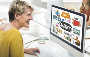 Woman looking at charity infographic on computer monitor, payroll giving concept