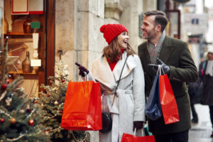 Couple Christmas shopping, woman pointing at shop window, small retailers Christmas concept