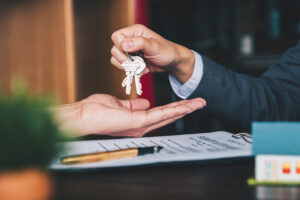 estate agent handing over keys to outstretched hand, negotiate a commercial lease concept