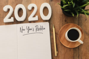 Business concept of top view 2020 year's resolution list with notebook, cup of coffee over wooden desk, SEO tips 2020 concept