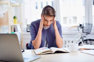 stressed businesswoman at desk, small business suicide concept