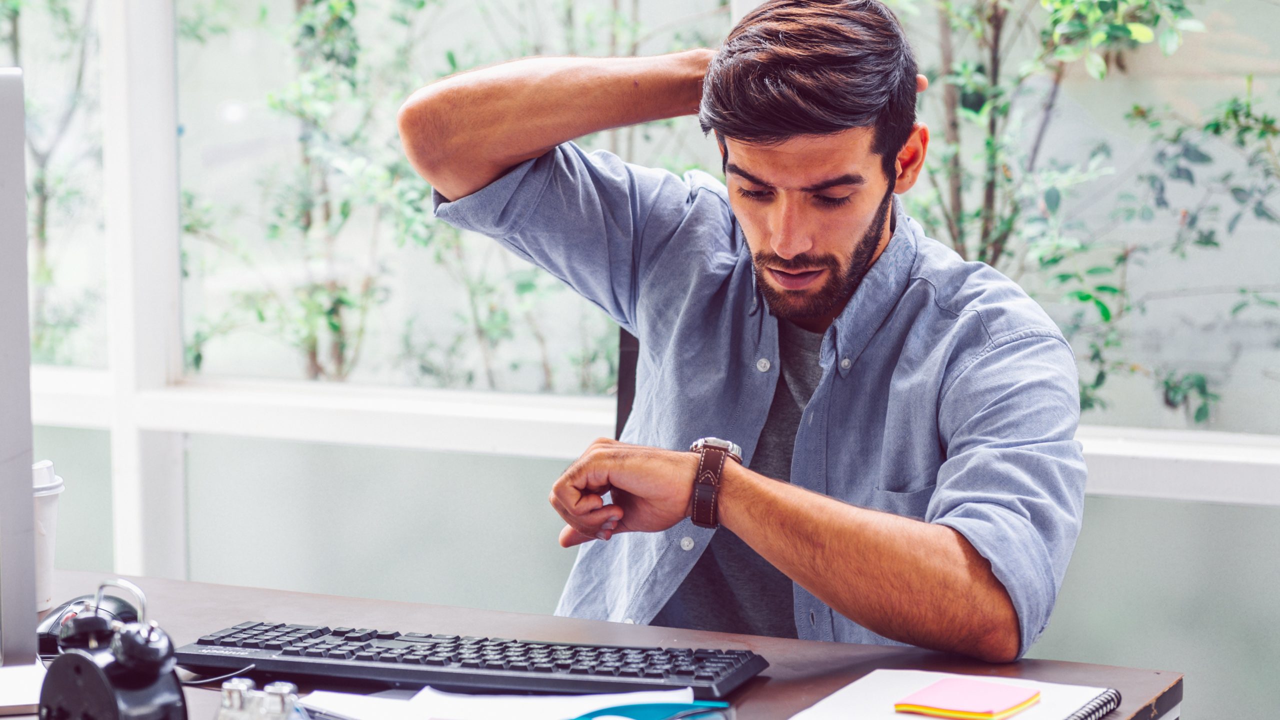 young trendy worker looking at watch, fintechs coronavirus concept