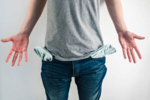 Man in jeans showing empty pockets, small businesses cash concept