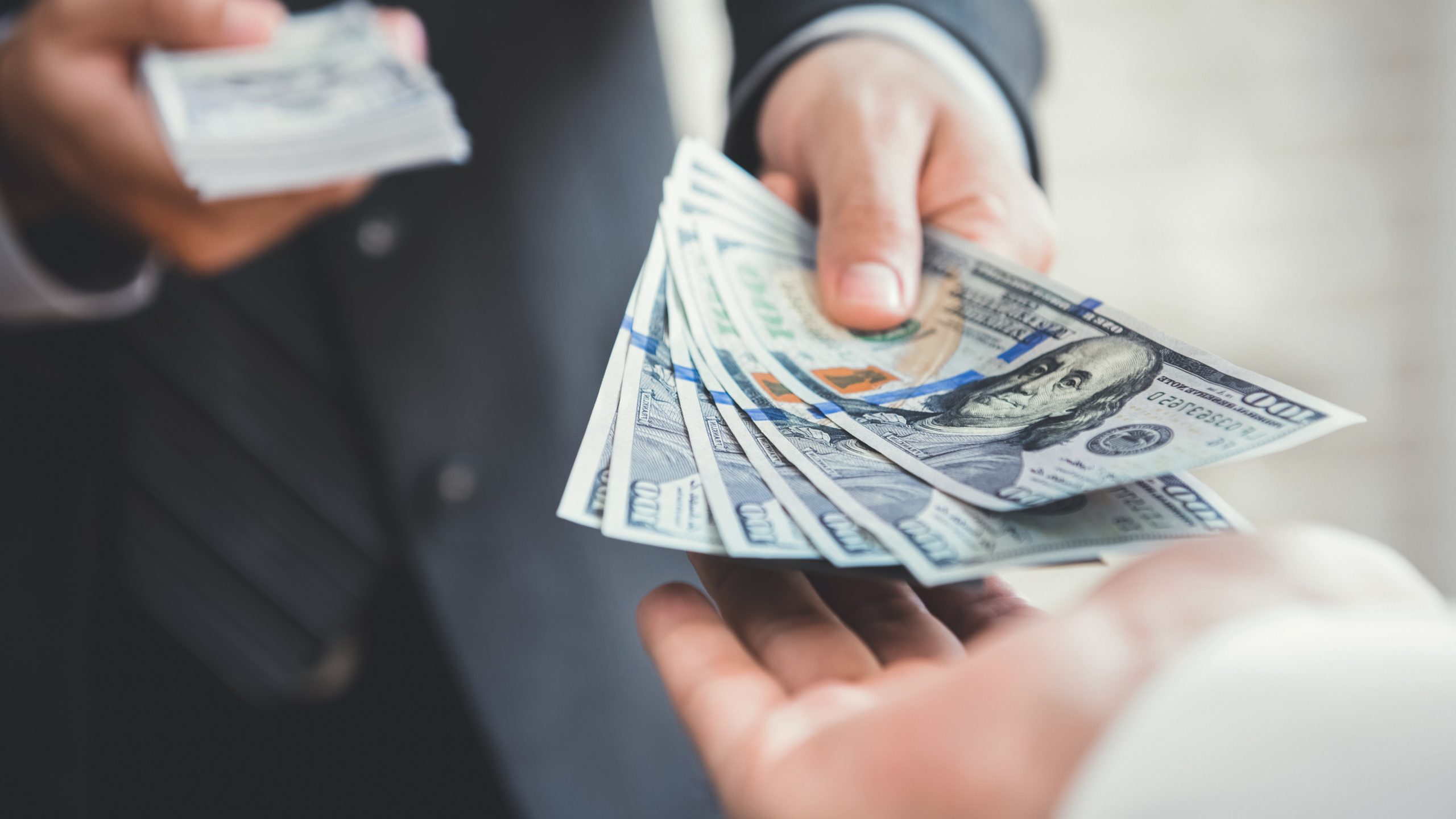 Businessman handing over money, selling your business without a broker concept