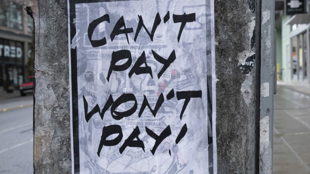 A sign that reads "Can't pay, won't pay" is plastered to a telephone pole to drum up support for a rent strike, repay Bounce Back Loans concept
