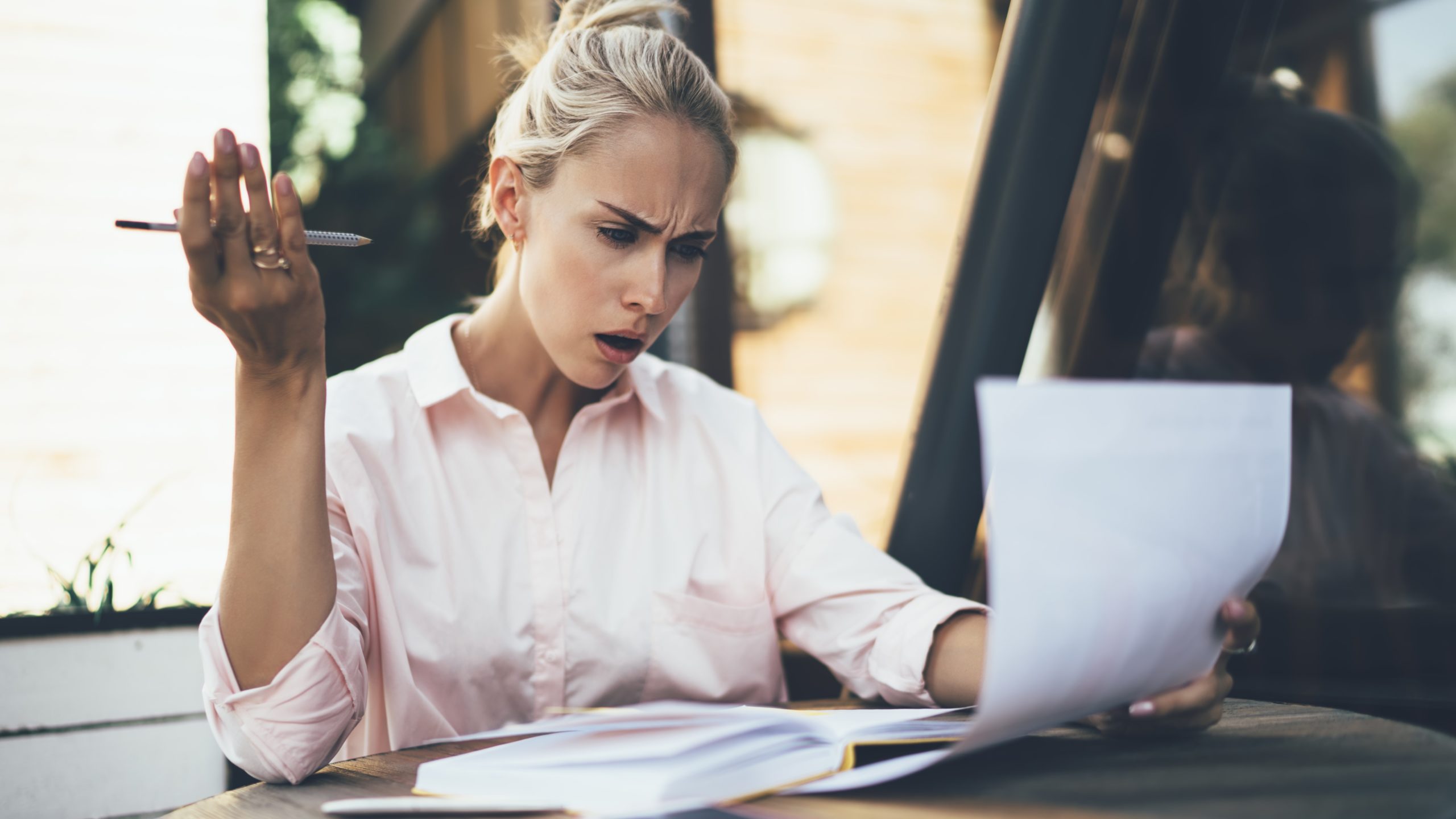 Woman shocked by what she reads on piece of paper, Growth Street businesses concept