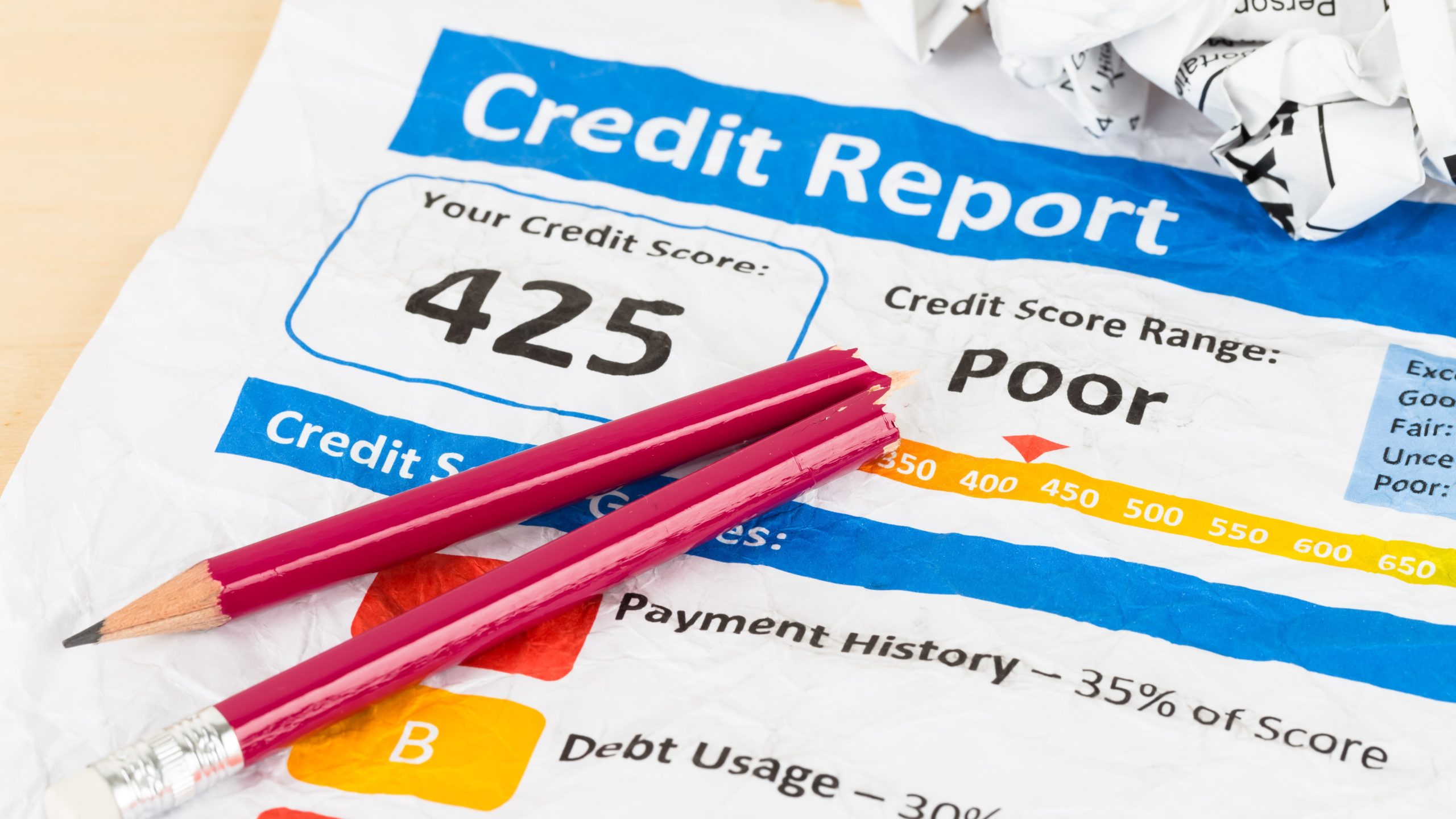 Poor credit score report on wrinkled paper with pen and calculator, bounce back loan repayment concept