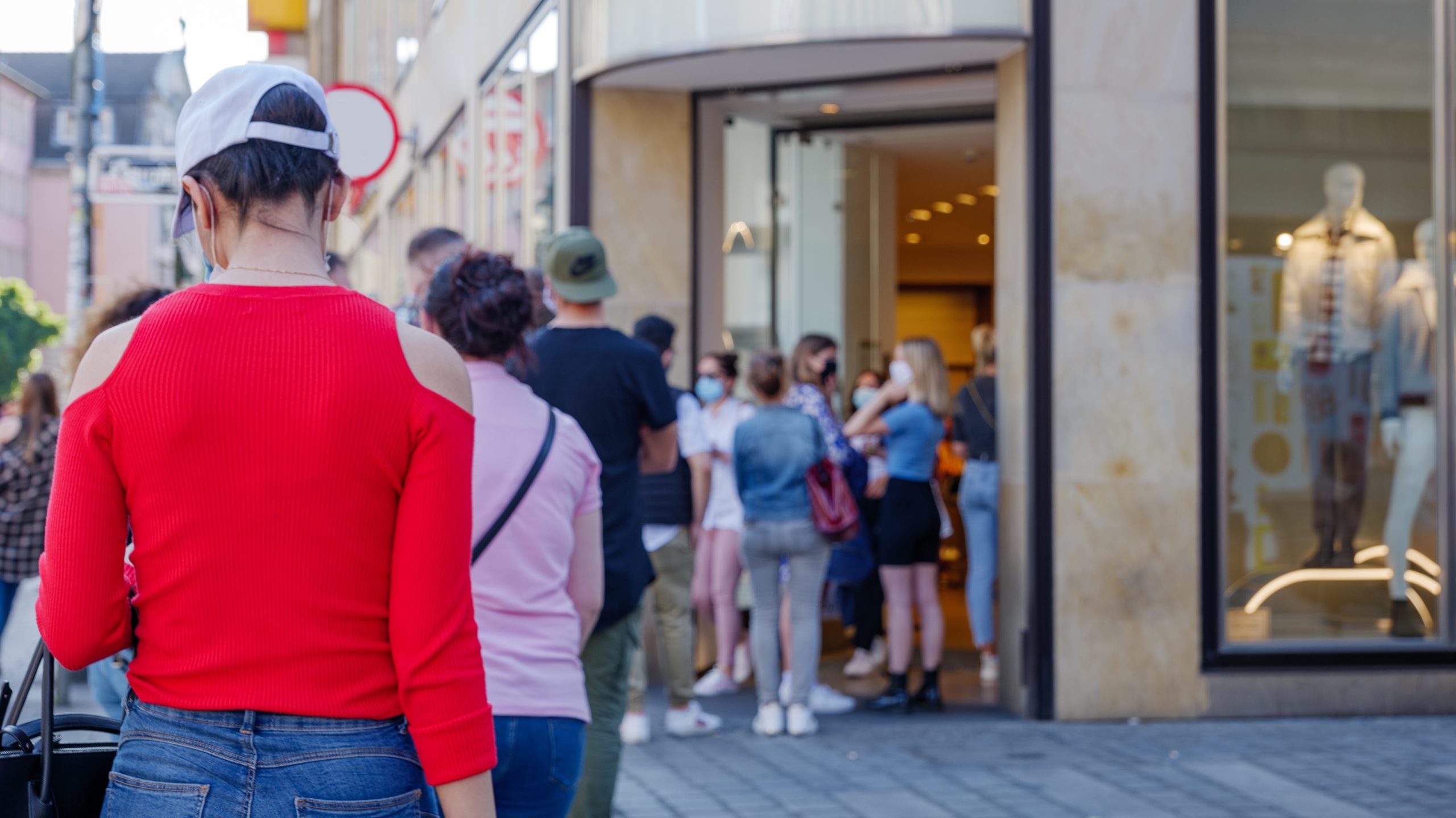 Queue of woman outside fashion boutique, return to trade post-lockdown concept
