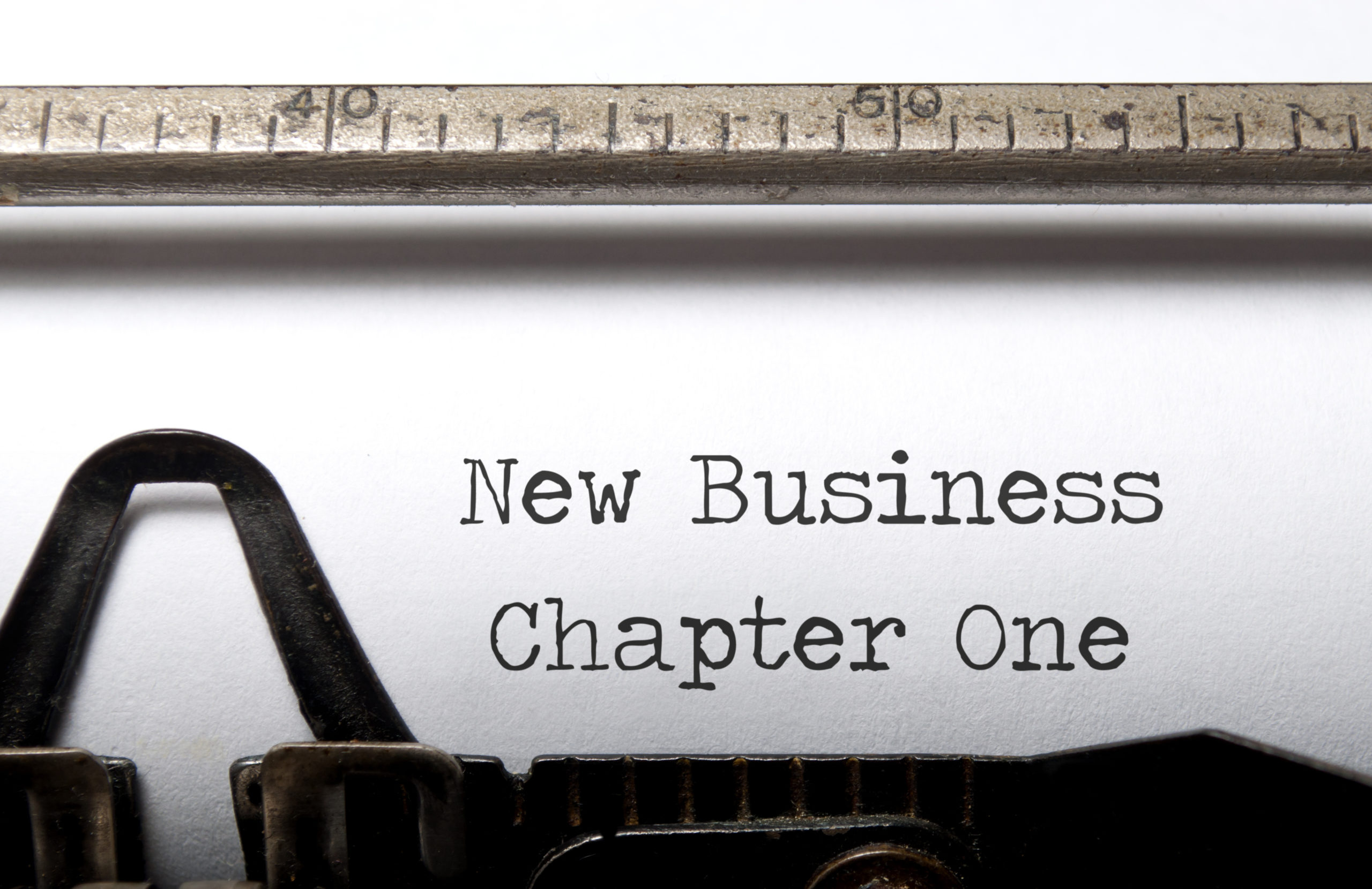 Typewriter with words "New Business Chapter One" on sheet of paper. Start a new business concept