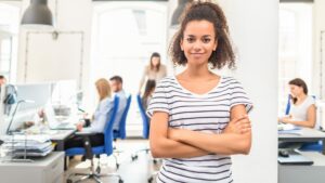 Confident woman arms folded in office, small business marketing strategies concept