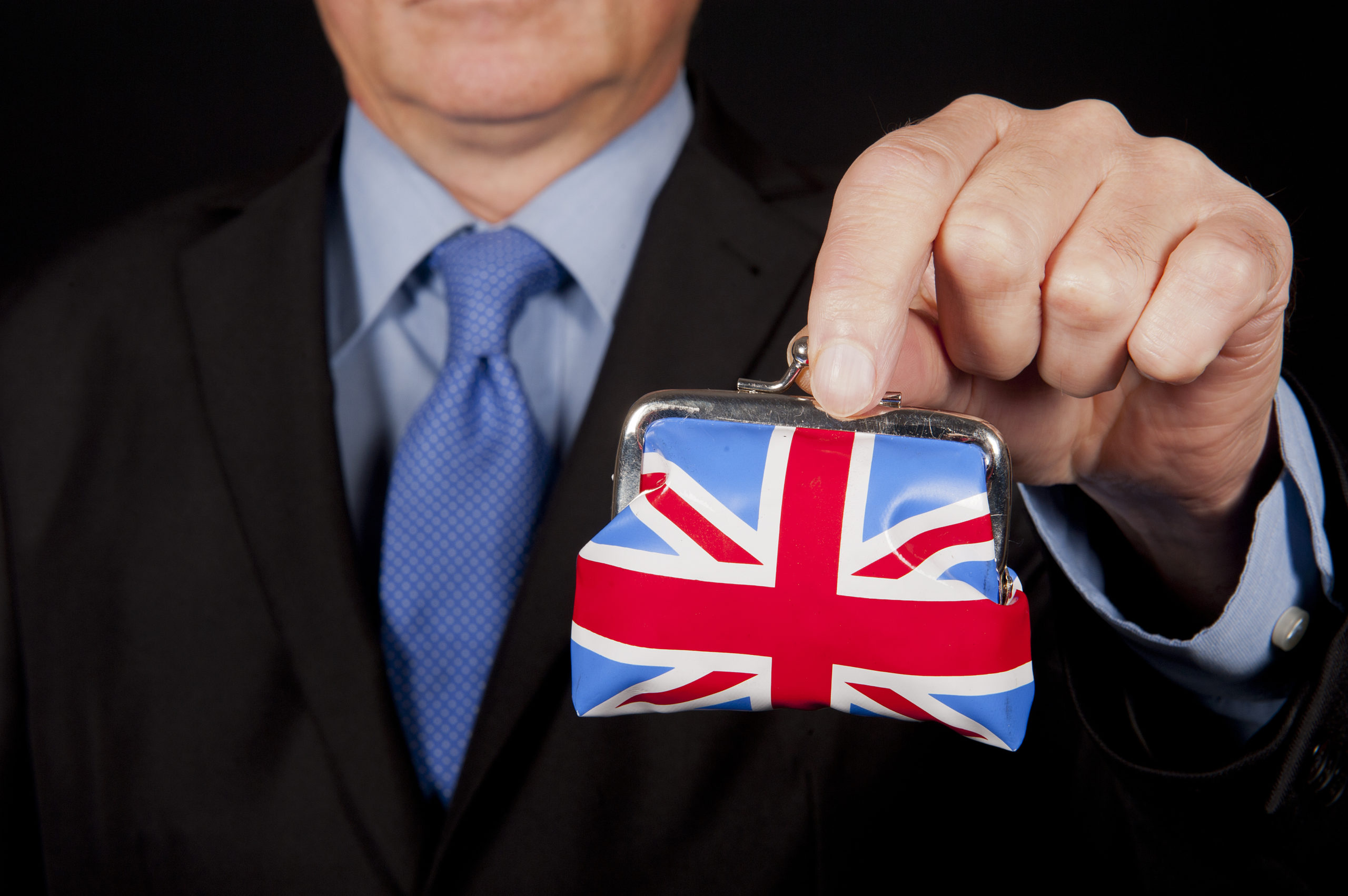 Businessman holding Union Jack purse, self-employed tax concept