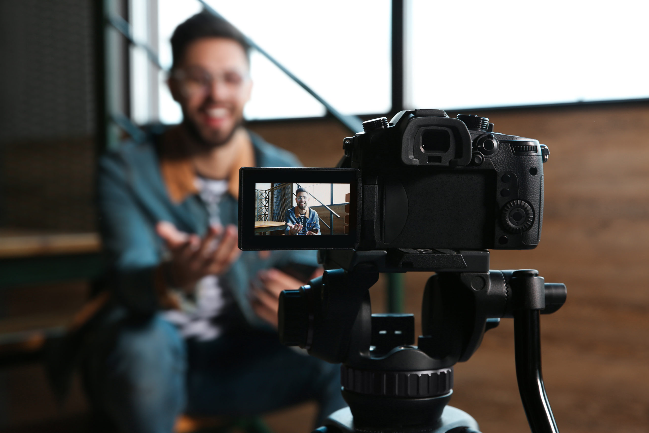 Young blogger recording video indoors, video ads concept
