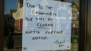 Shop door with handwritten closed due to coronavirus sign, Covid help concept