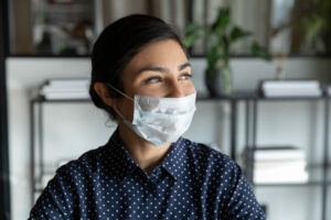 Young Indian woman looking optimistic wearing facemask, second CBILS loan concept