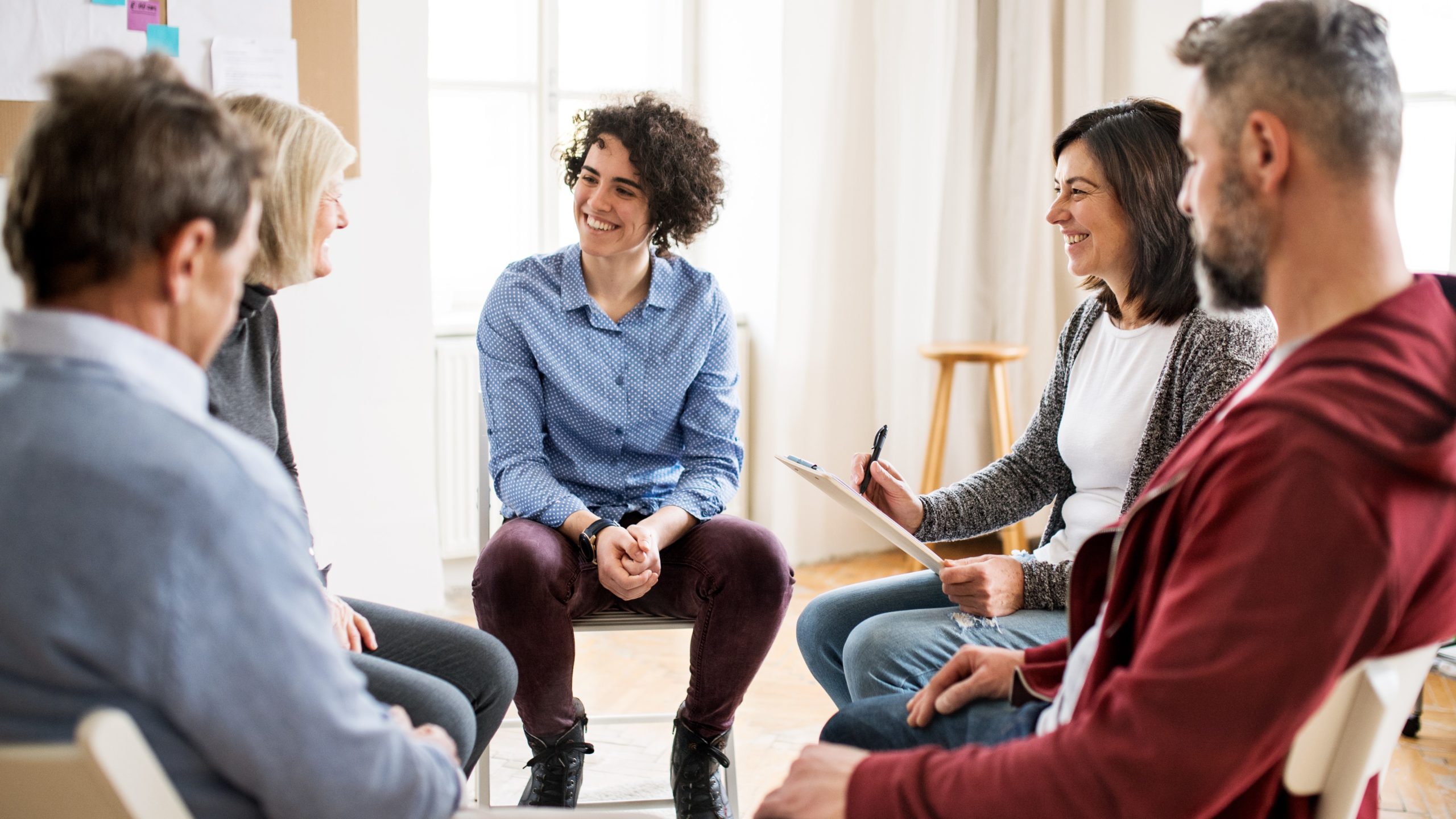 Group sitting in circle, peer networking concept
