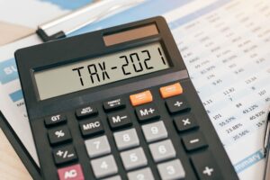 Calculator displaying Tax 2021, small business tax concept