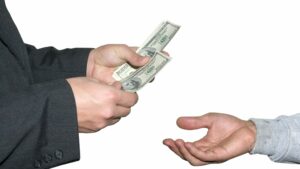 Outstretched male hand accepting dollars from older male hands, Bank of Mum and Dad concept