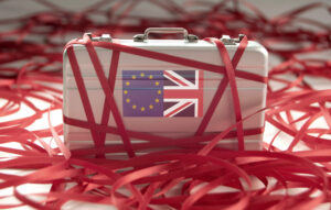 Suitcase with EU and Union Jack flags on side wrapped up in red tape, EU one-stop-shop concept