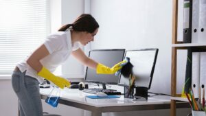 Woman cleaning computer screen in office, terminating a contract concept