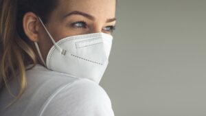 Young woman wearing facemask, pinged concept