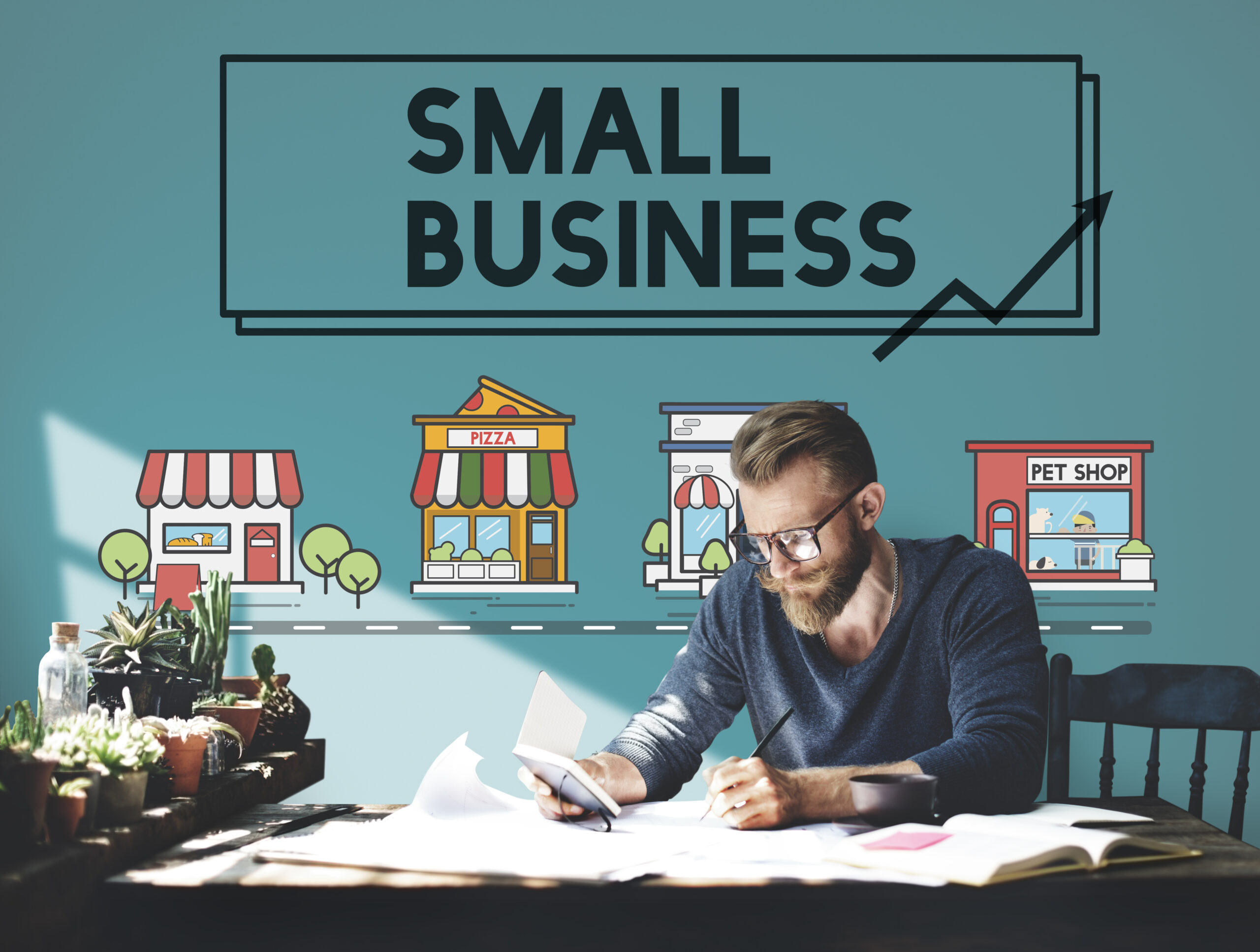 bearded man poring over table with small business legend behind him, marketing budget concept
