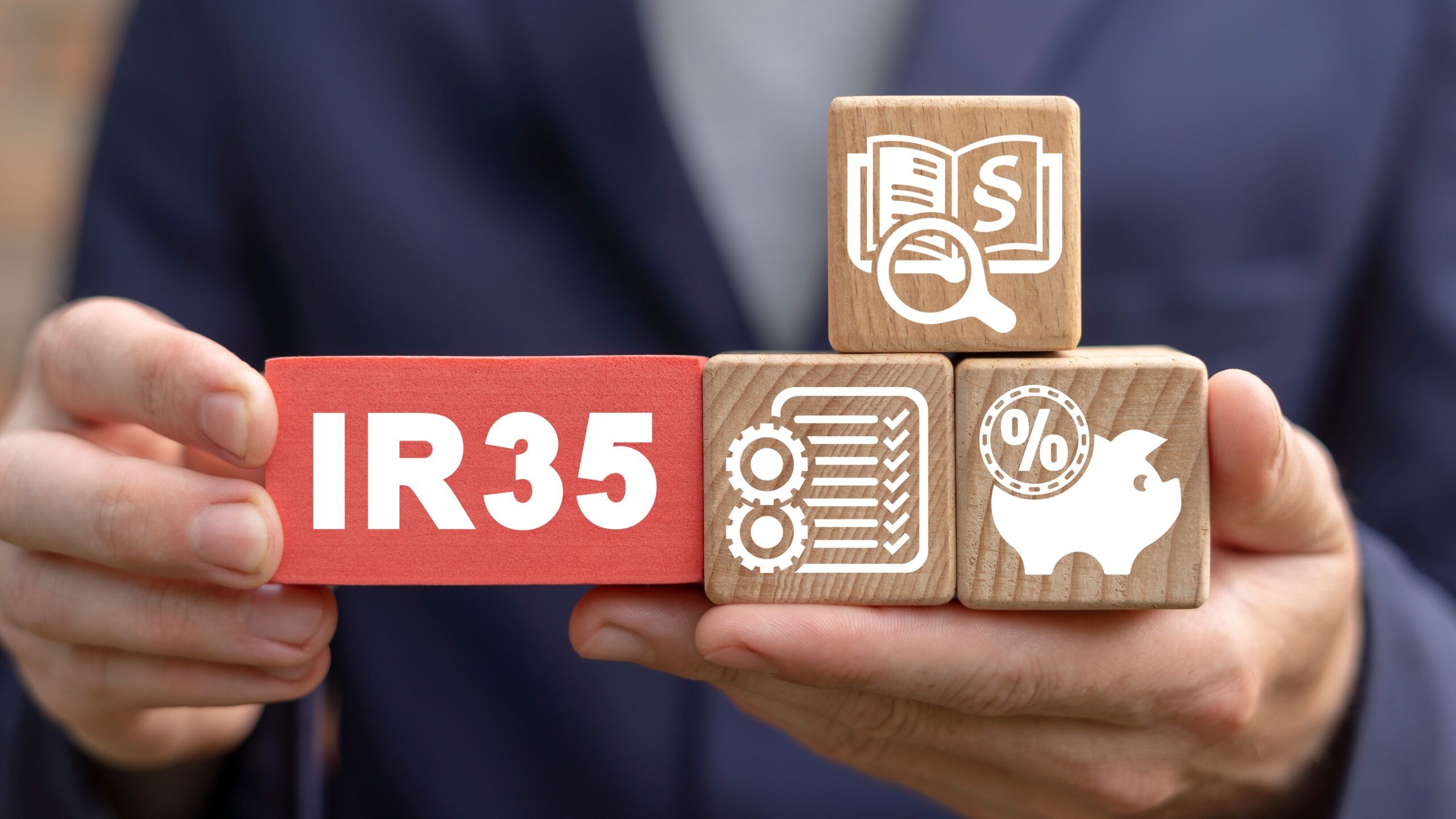 Man holding building blocks with symbols, IR35 concept