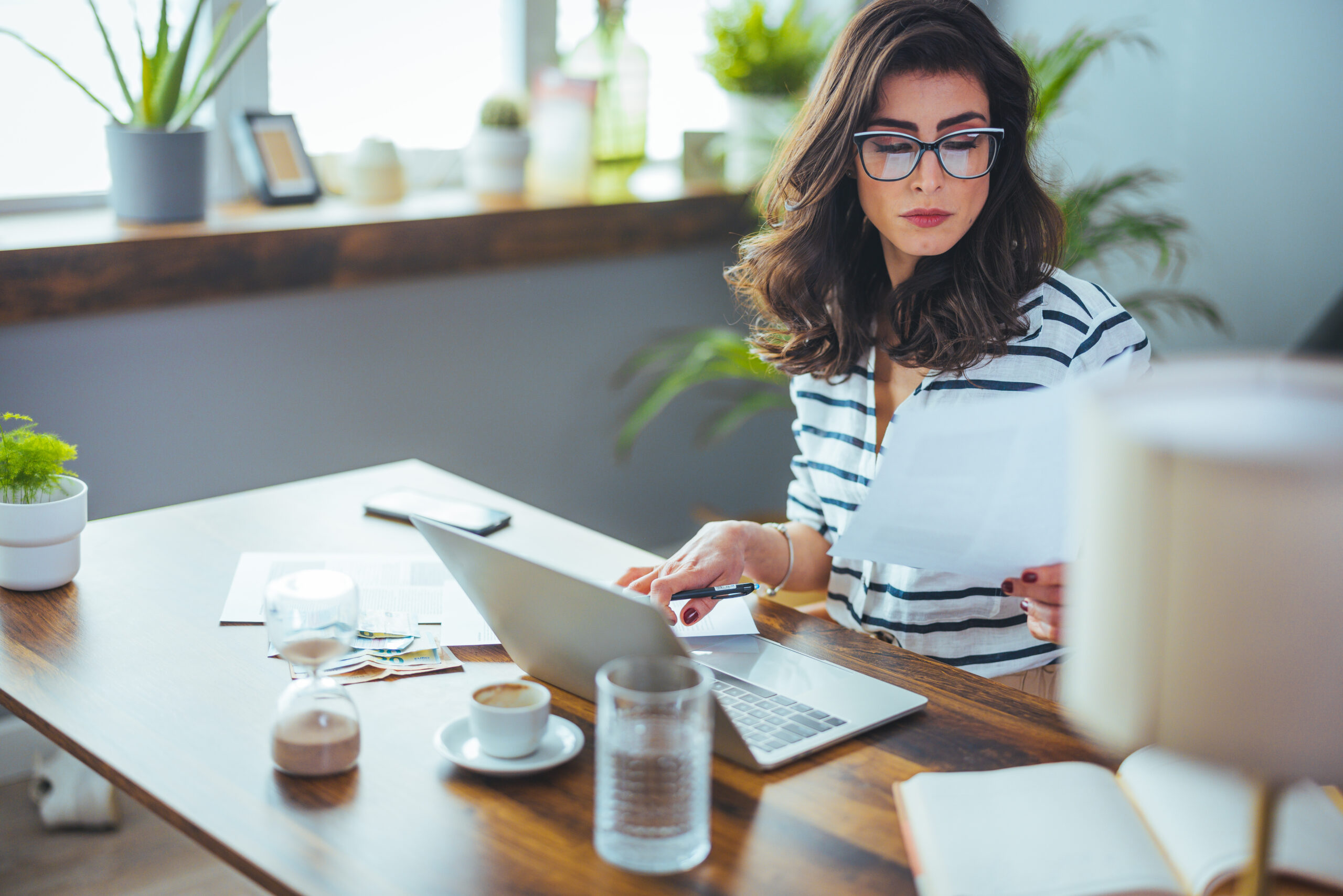 Black-haired woman studying computer screen doing taxes, Making Tax Digital April concept