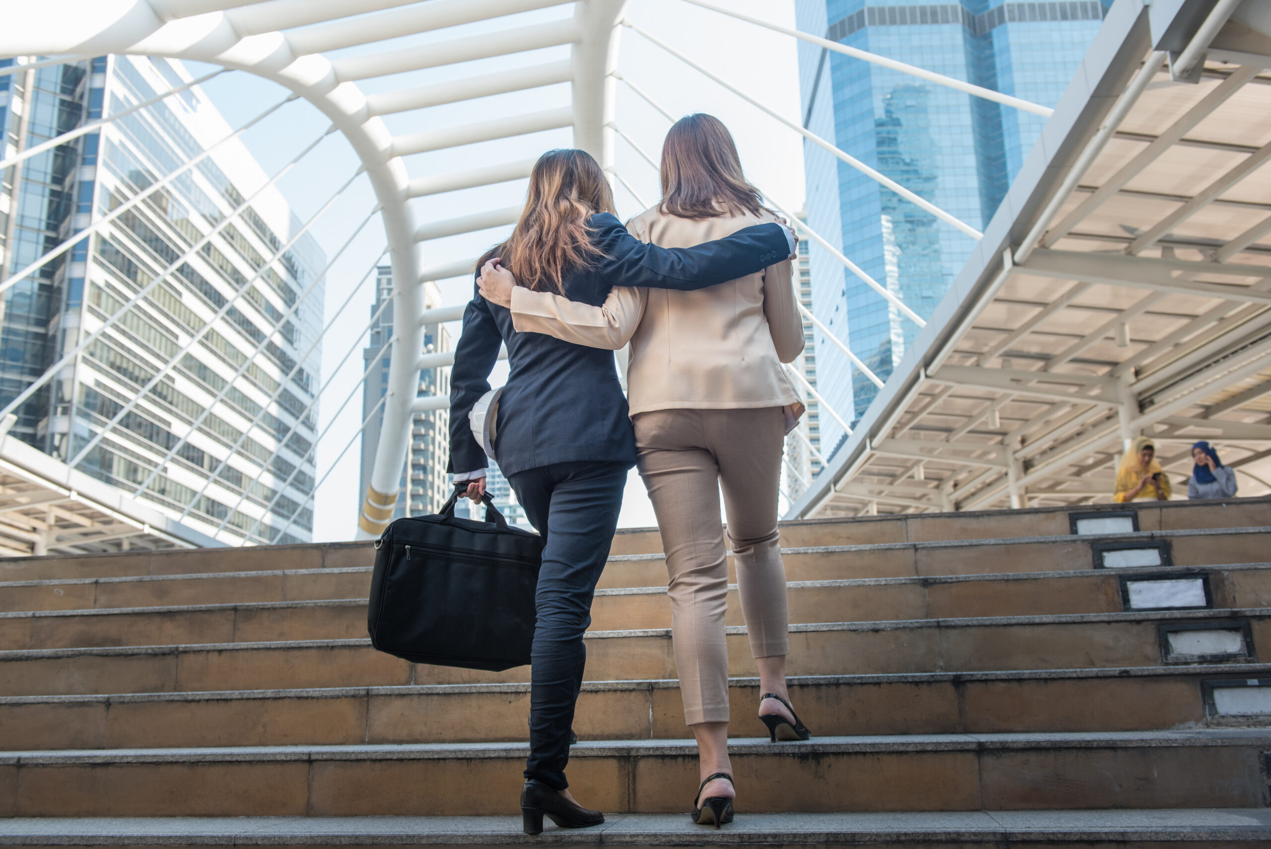 Two businesswoman with arms around each other, raising start-up capital concept