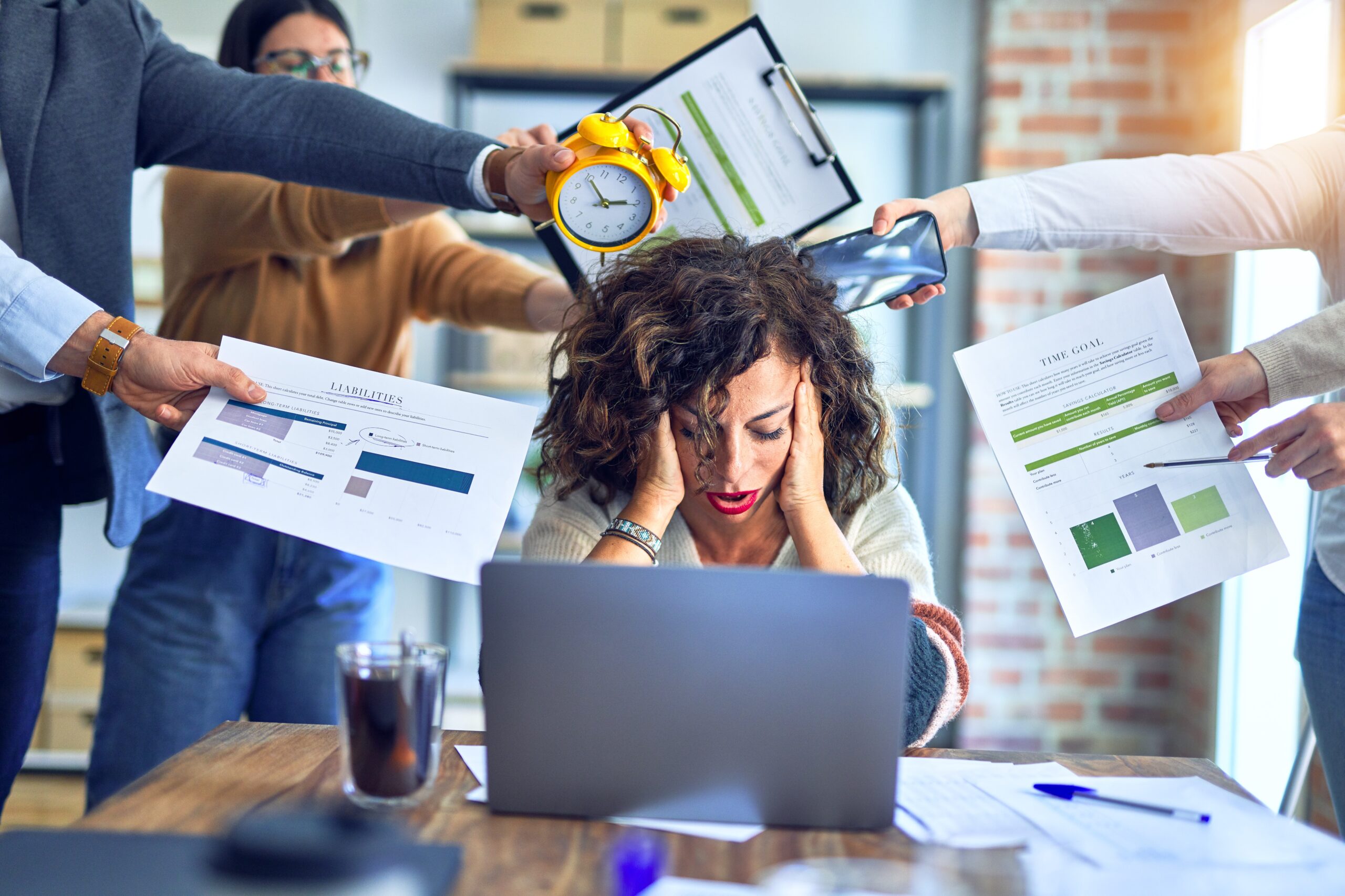 Young woman with head in hands overwhelmed at work, burnout concept