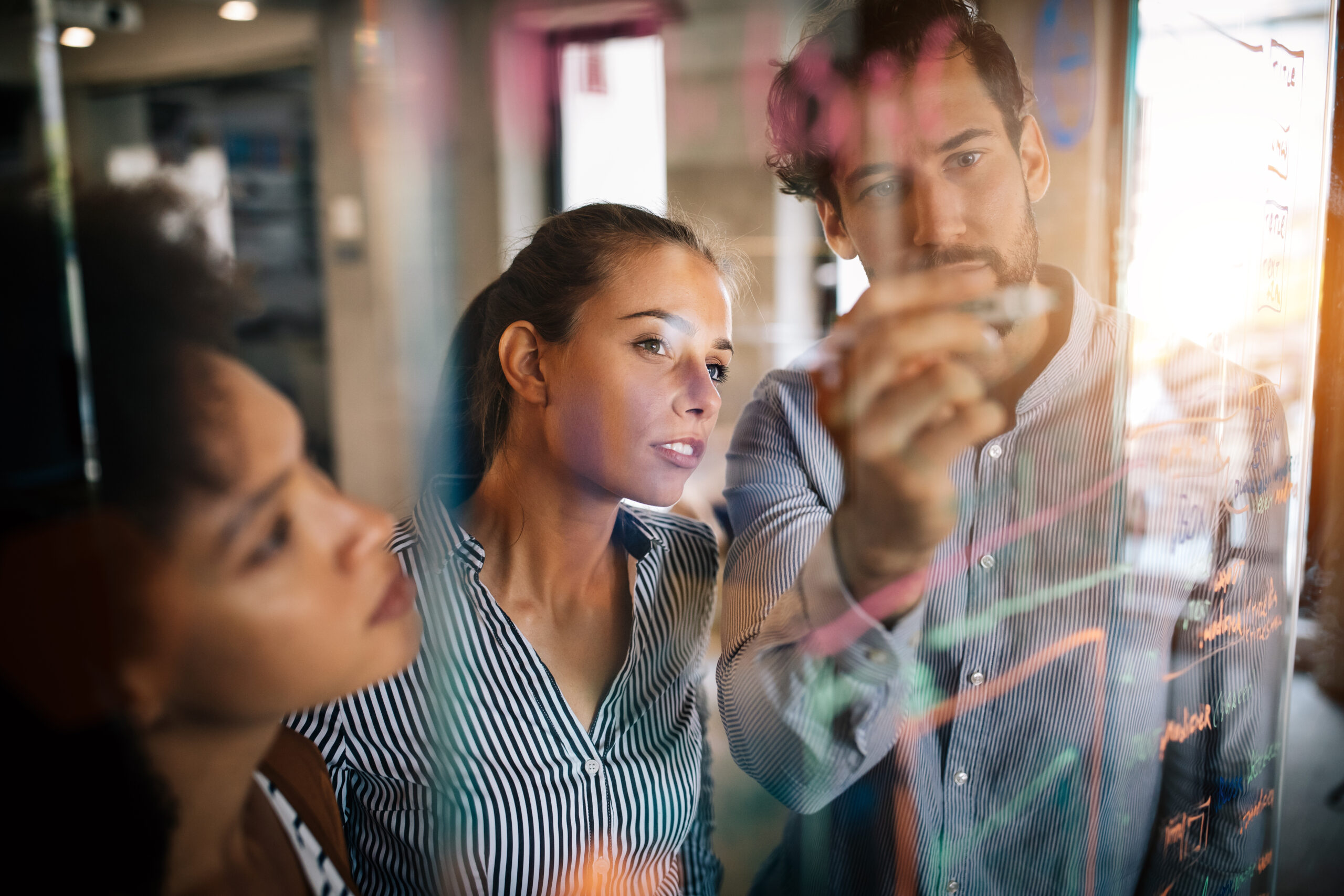 three work colleagues examining a virtual display, business technologies concept