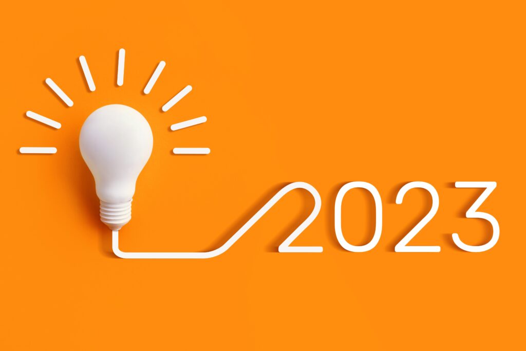 2023年经营理念的概念。灯泡与flex拼写出2023橙色背景