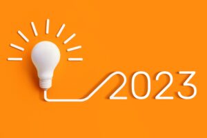 Business ideas 2023 concept. Lightbulb with flex spelling out 2023 on orange background