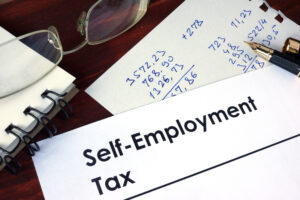 Sole traders tax concept. Paper with words self-employment tax on a wooden background.