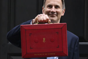 Spring Budget 2023 concept. Chancellor Jeremy Hunt with red briefcase outside 11 Downing Street, March 15 2023