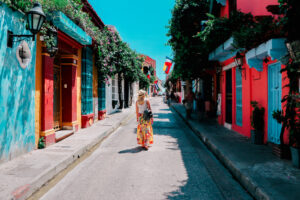 Young woman walking on a colourful street in old city of Cartagena, Colombia. Digital nomad visa America
